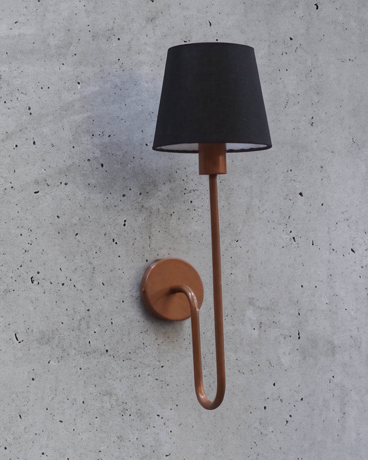 Stylish wall-mounted lamp with a black lampshade and luxurious copper metal arm, adding a touch of sophistication.