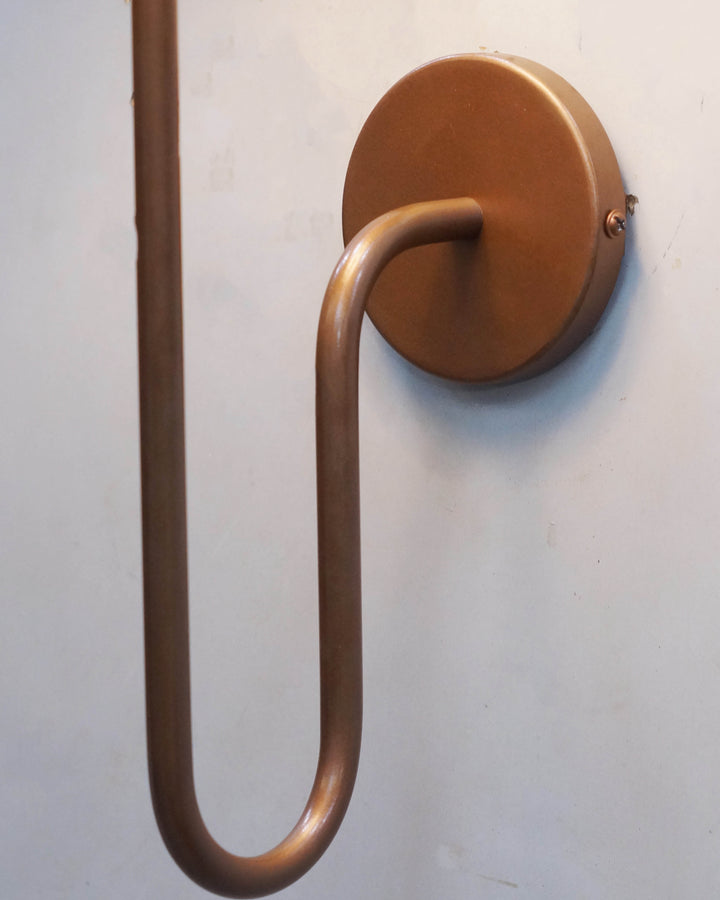 Elegant wall lamp design with a black shade and a unique copper metal arm, perfect for modern interiors