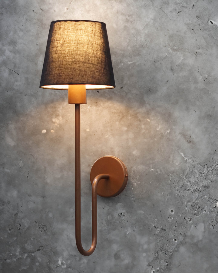 Urban Elegance Wall Lamp with a sleek black lampshade and copper-colored metal arm, mounted on a wall