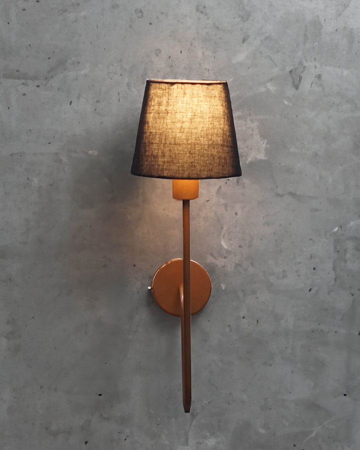 Modern industrial wall lamp featuring a minimalist black shade and elegantly curved copper arm